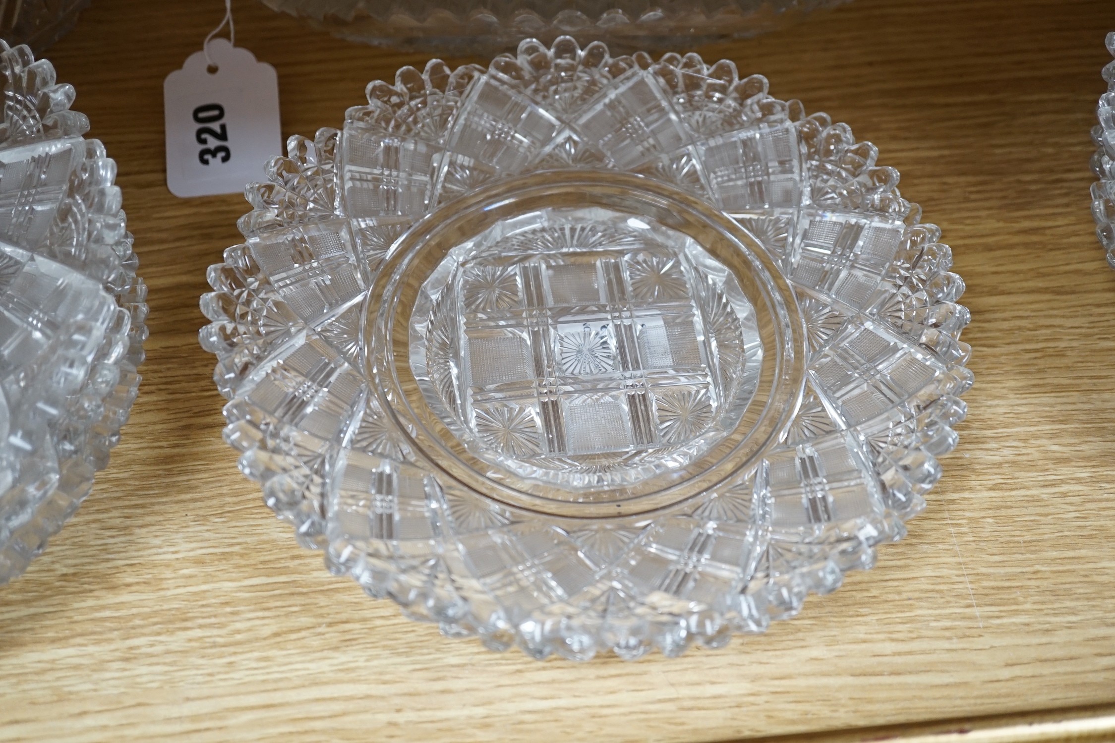 Eight 19th century cut glass circular plates probably Irish, a similar octagonal dish, a later oval cut glass dish and a similar punch bowl, bowl 26 cms diameter